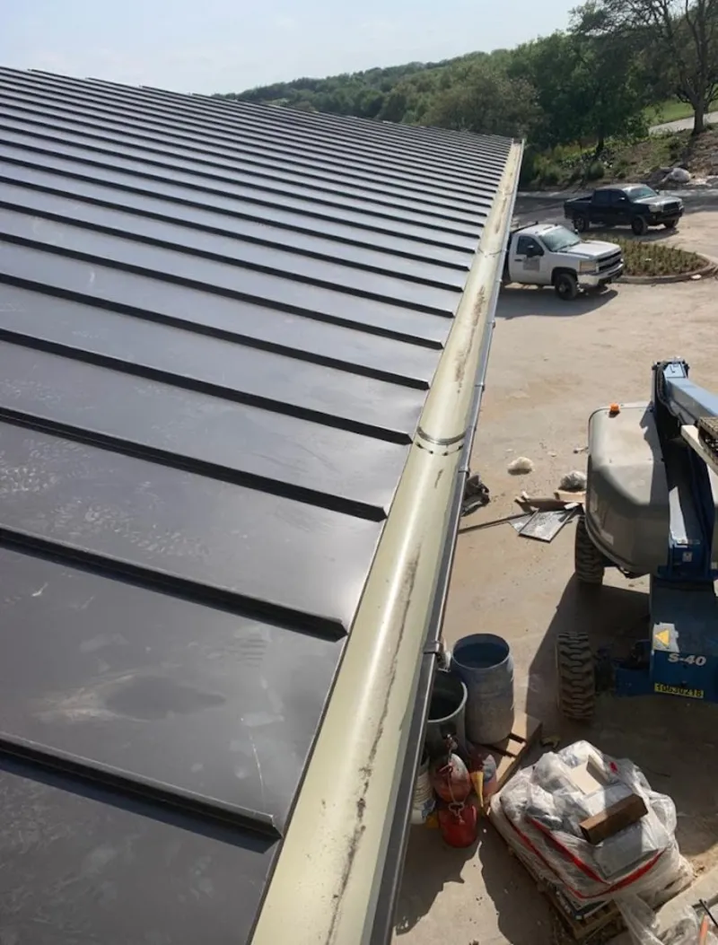 Standing seam panel and gutter detail on a metal roofing jobsite in Iron Mountain